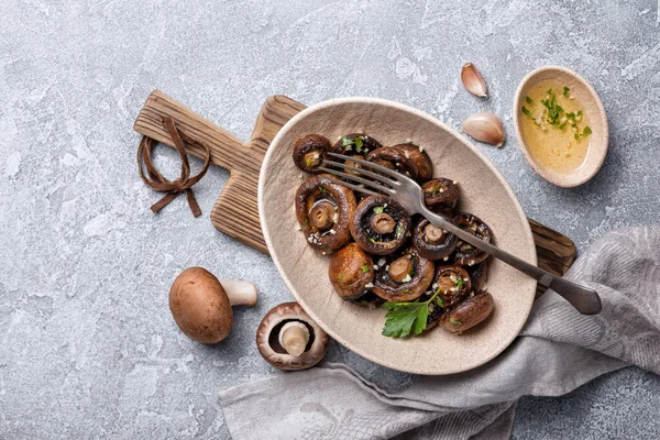 Kavanozda ızgara şampiyon mantarları ve gri beton arka planda baharat.