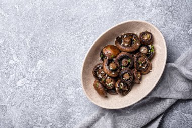 Kavanozda ızgara şampiyon mantarlarının üst görüntüsü. Gri beton arka planda baharat ve fotokopi alanı.