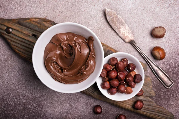 味道鲜美的巧克力奶油或褐色坚果奶油 糊糊和整个榛子 作为混凝土背景下自制甜点的配料 — 图库照片