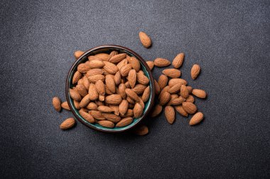 Badem cevizinin en üstteki görüntüsü. Siyah beton arka planda şekerleme malzemesi olarak kasede.