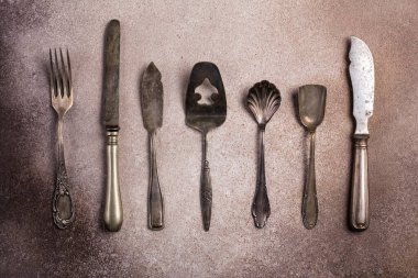 Kahverengi beton arka planda gümüş çatal bıçak ya da gümüş çatal bıçak üst görünümü