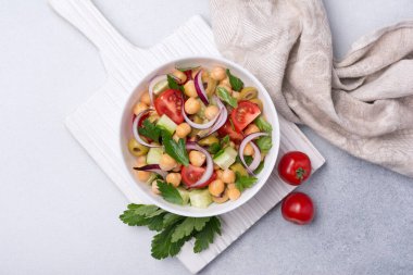 Sağlıklı ve lezzetli vejetaryen yemekleri. Maydanozlu nohut salatası, kiraz domatesleri, soğan, salatalık ve yeşil zeytinler.