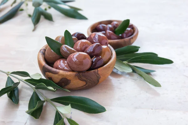 Tasty Olives Wooden Bowls Green Branches Light Background — Stok fotoğraf