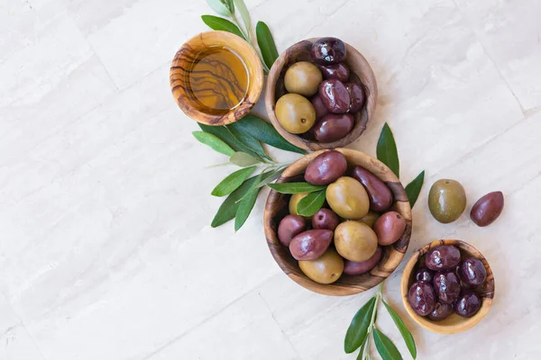 Tasty Olives Oil Wooden Bowls Green Branches Light Background — Foto Stock