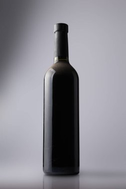 Bottle of vintage red wine on grey background