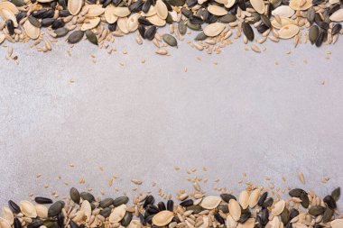 Sağlıklı beslenme için kabak, ayçiçeği ve keten tohumlarının üst görüntüsü kopya alanı olan gri beton arka planda