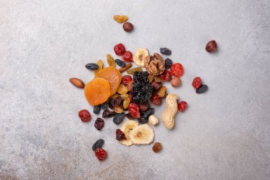 Kurumuş meyve, böğürtlen ve fındık, gri beton arka planda lezzetli ve sağlıklı yemek için malzeme olarak üst görünümü