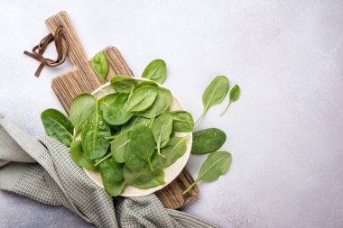 Tahta üzerinde yeşil bebek ıspanağı ve gri beton arka plan manzarası.