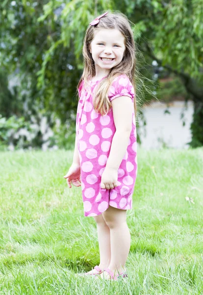 Petite fille debout dans l'herbe — Photo