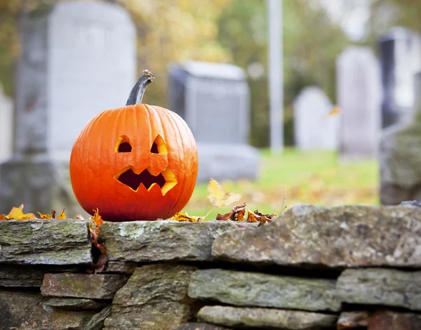 Abóbora no cemitério com folhas de outono — Fotografia de Stock