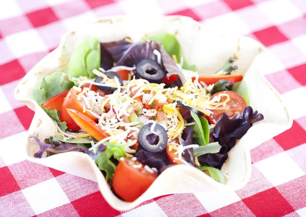 Taco salad on checkered tablecloth — Stock Photo, Image