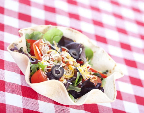 Taco salad on checkered tablecloth — Stock Photo, Image