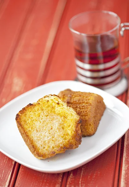 Opékané kukuřice muffin s máslem a šálek čaje — Stock fotografie