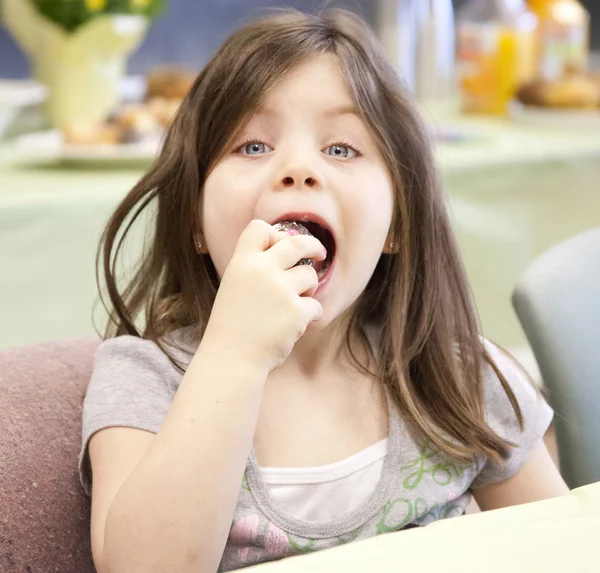 Jolie fille mangeant un beignet — Photo