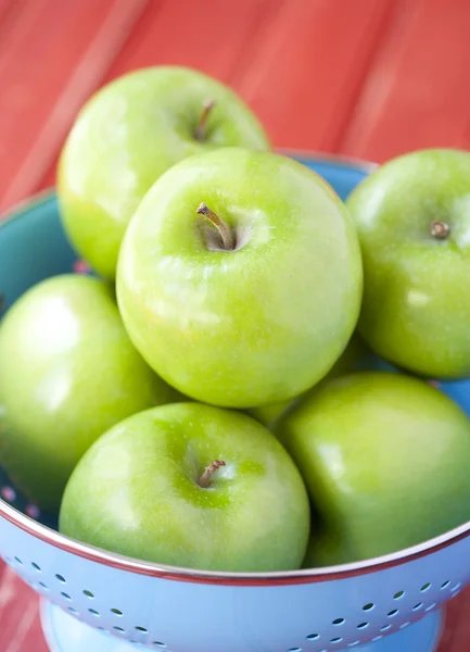 Zelená jablka v modrý cedník — Stock fotografie