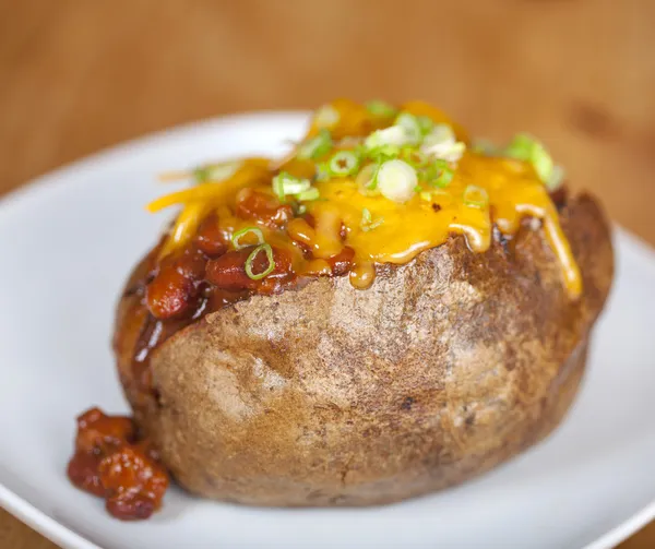 Loaded baked potato with chili and cheese — Stock Photo, Image