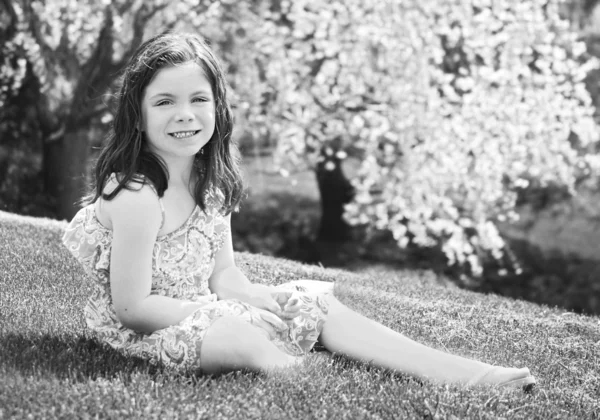 Kleines Mädchen sitzt im Gras — Stockfoto