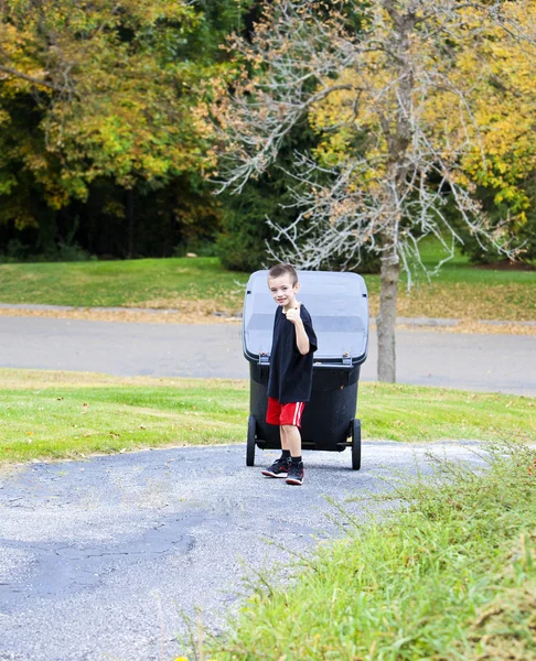 ゴミ箱をもたらす若い少年は、私道を持ち上げることができます。 — ストック写真