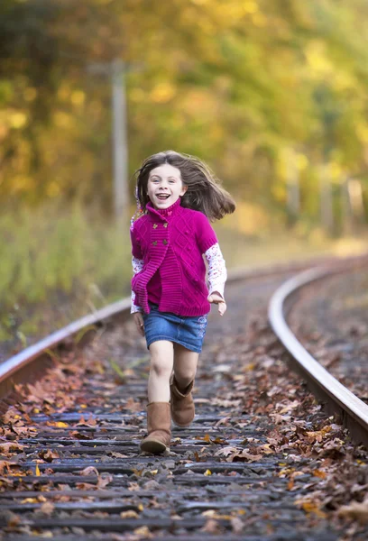 漂亮的小女孩在火车轨道上运行 — 图库照片