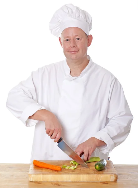 Cuoco maschio che taglia verdure su un tagliere — Foto Stock