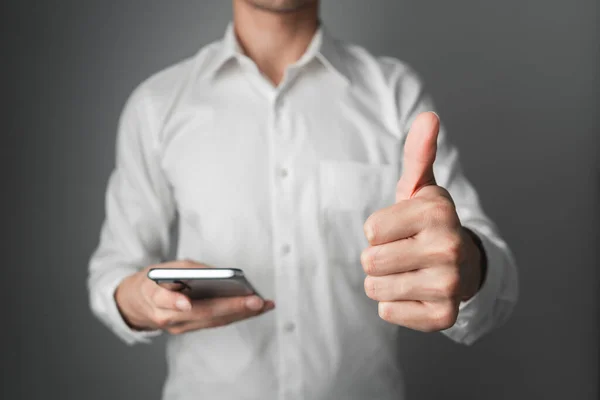 ビジネスマンは親指を立ててスマートフォンを持っている お客様満足コンセプト — ストック写真
