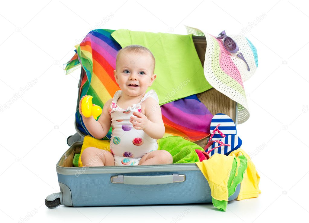 Baby girl sitting in suitcase with things for vacation travel ⬇ Stock