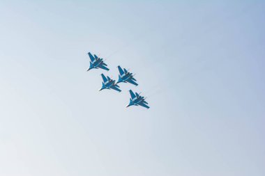 Pilotlar avcı uçaklarında yüksek akrobatik hareketler gösteriyor. Mavi gökyüzündeki uçak bombacıları. Gökyüzünde askeri uçak var.