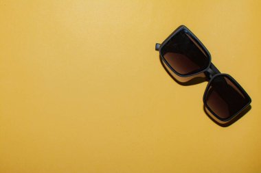 Black glasses on a yellow background. Layout for designers