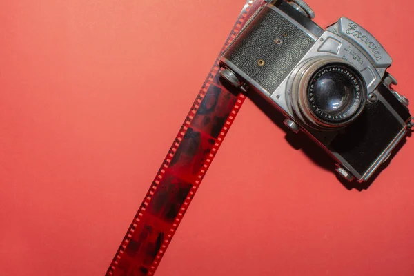 赤い背景に古いカメラとテープ 写真スタジオのデザイン — ストック写真
