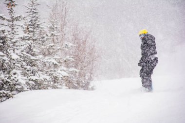 Snowboardcu dağdan iniyor. Çok şiddetli kar yağıyor.