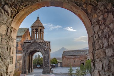 Kemerlerin arasından kilise. Dini kültür mirası. Eski duvarlar, kemer ve kilise