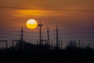 Güzel günbatımı ve elektrik için metal kuleler. Büyük kızgın güneş
