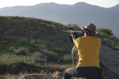 Silahlı bir avcı. Elinde silah tutan bir adam.