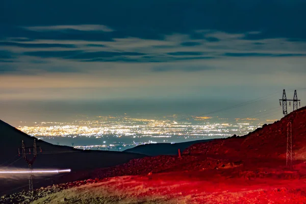 Night city and beautiful sky. Multi-colored clouds on the night city. City lights at night