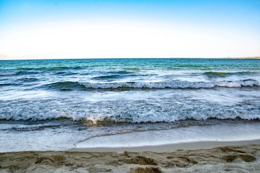 Blue waves of the sea and golden sand. Rest on the sea