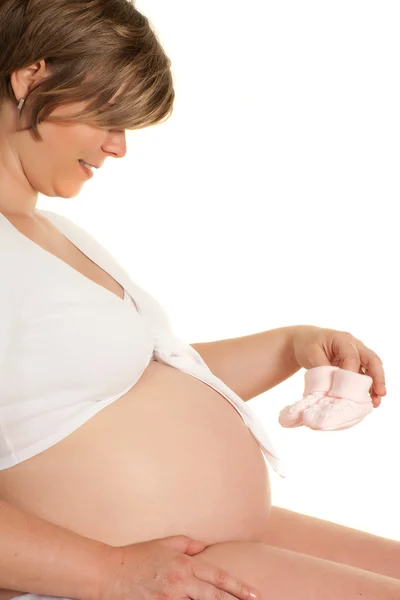 Calcetines de bebé rosa y vientre embarazada — Foto de Stock