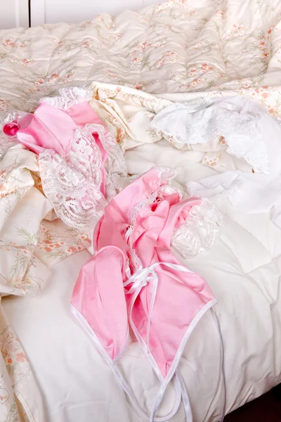 Różowy baby-doll na łóżku — Zdjęcie stockowe