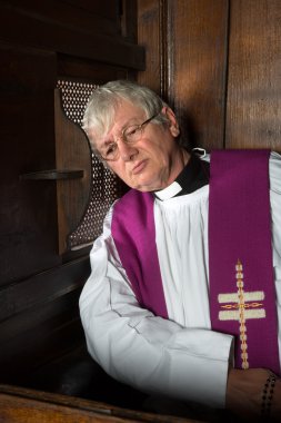 Vicar in confession booth clipart
