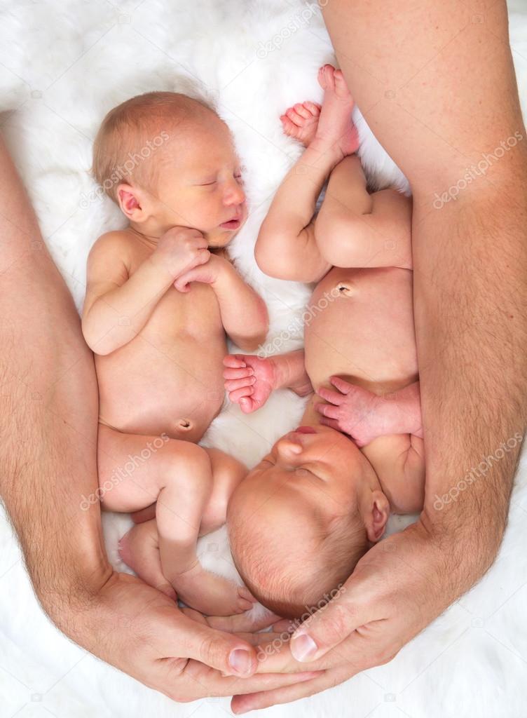 Father's arms around twins