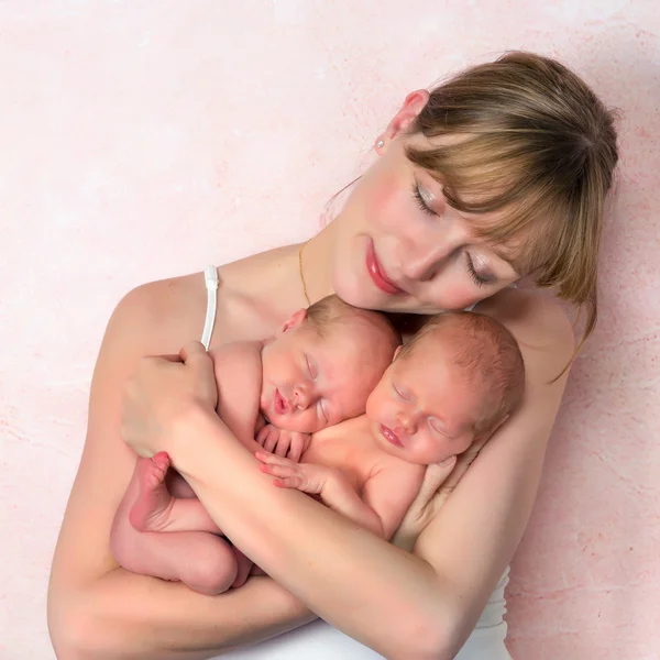 Tender mother with newborn twin babies — Stock Photo, Image