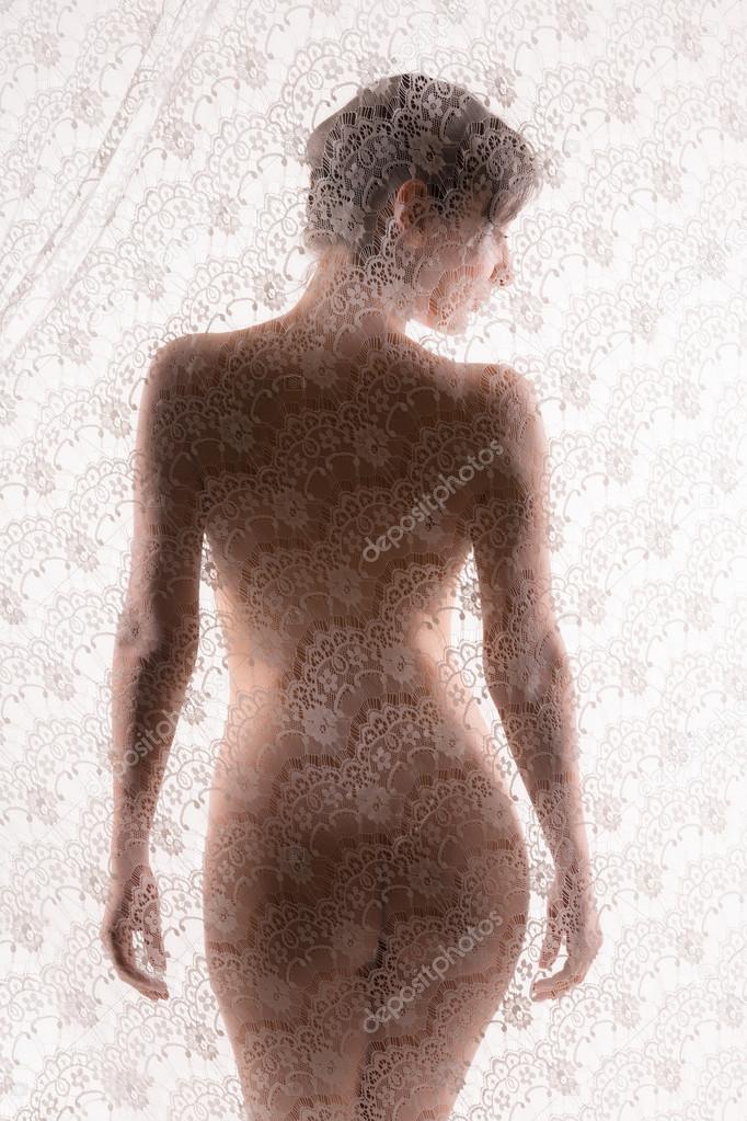 Naked woman behind lace curtain