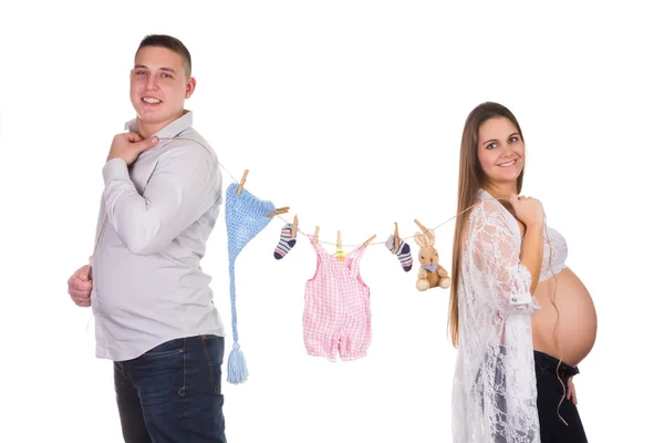 Happy pregnant couple with baby clothes — Stock Photo, Image