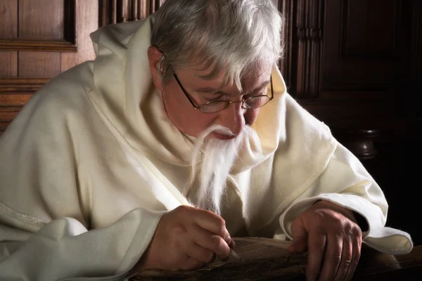 Бородатый монах пишет пером — стоковое фото