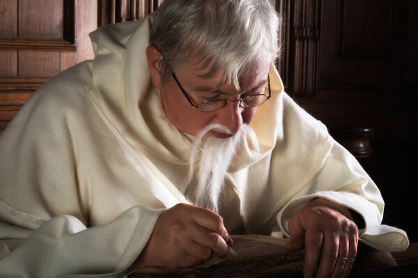 Bearded monk writing with quill