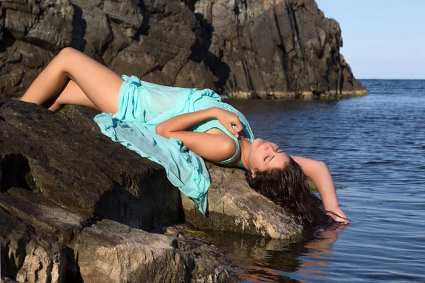 Plaj kaya üzerinde güneşlenme kadın — Stok fotoğraf