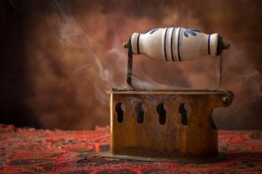 Antika Victoria kömür demiri eski kumaşın üzerinde duruyor.