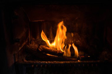 Eski bir şöminede yanan ateşin yakın çekimi, kullanılmayan bir şömine ile mevcut bir görüntüde birleşmek için kullanılabilir.