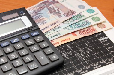 grafikler, hesap makinesi ve para.