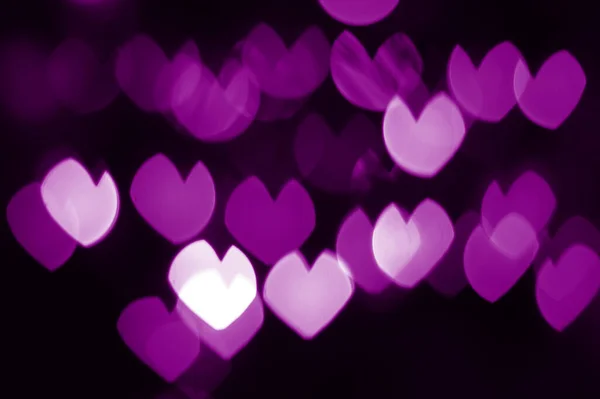 Bokeh fondo de terciopelo violeta corazones de color por la noche — Foto de Stock