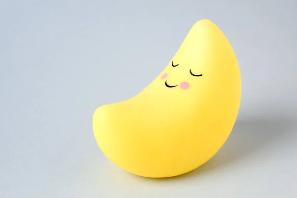 Mavi arka planda Ay şeklinde eğlenceli sarı gece lambası.